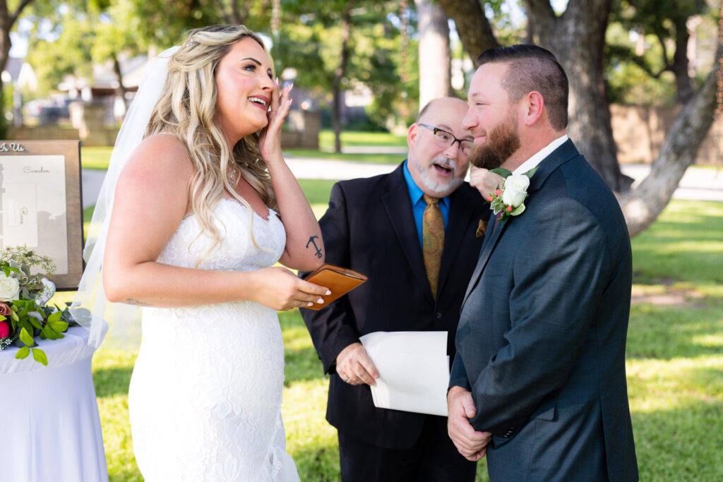 Bride and groom wiping tears from eyes and laughing during outdoor intimate elopement wedding ceremony