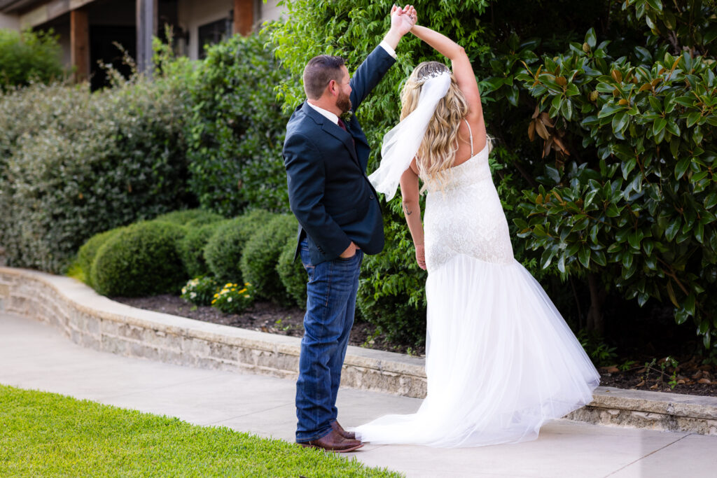 Wedding couple doing a twirl on walking path