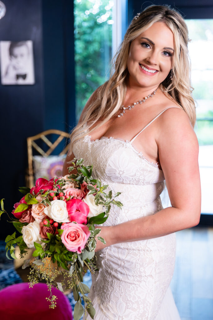 Bride holding pink flower wedding bouquet inside cute and chic blue hotel bar