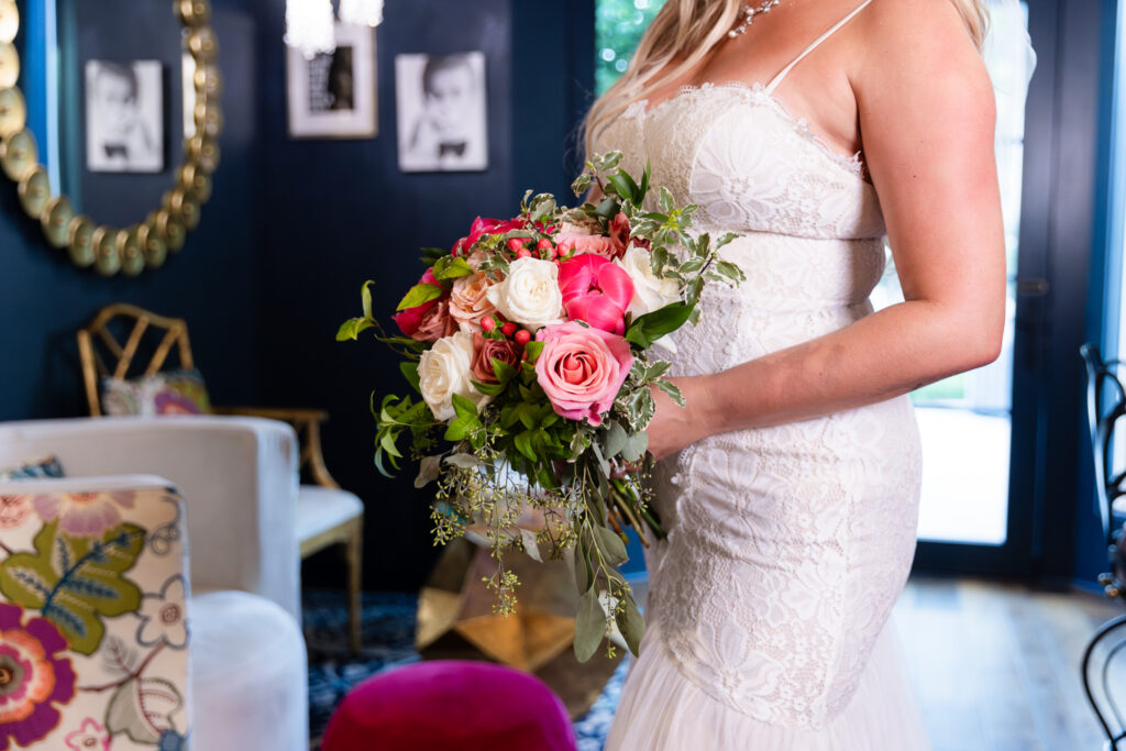 Pink flower wedding bouquet inside cute and chic blue hotel bar