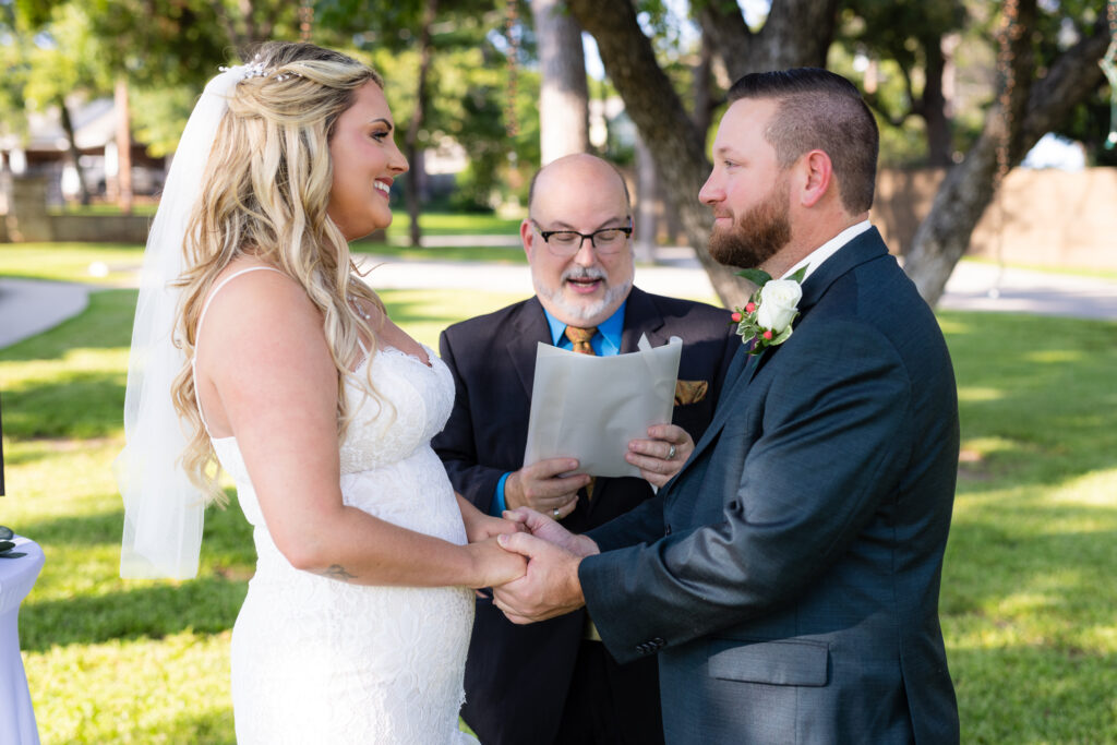 Bride and groom smiling and while holding hands during intimate elopement ceremony