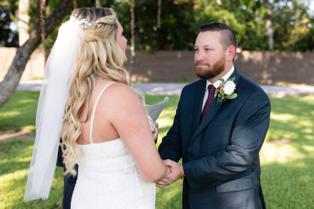 Groom holding bride's hands during intimate elopement ceremony