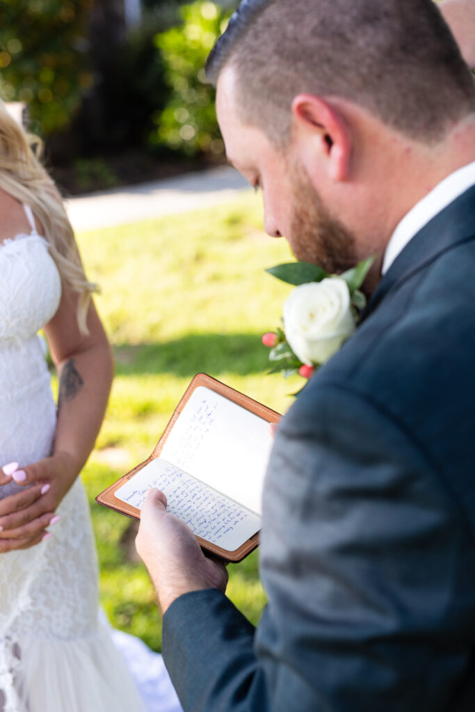 Groom reading vows from custom leather vow book