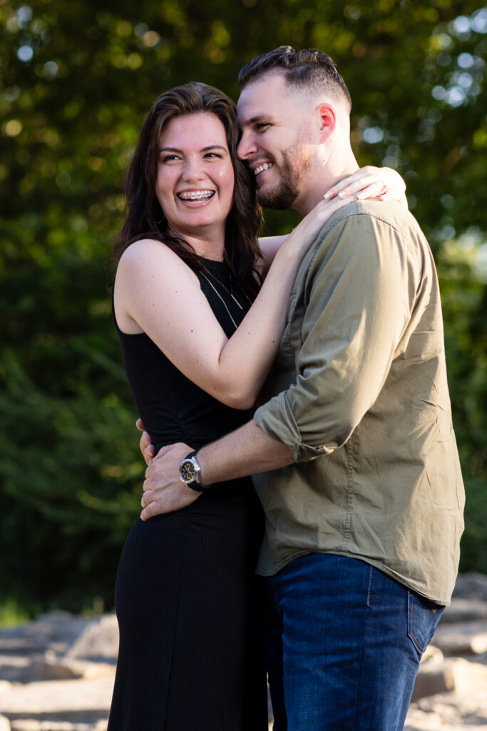 Man and woman hugging and laughing during engagement session at beautiful park in DFW