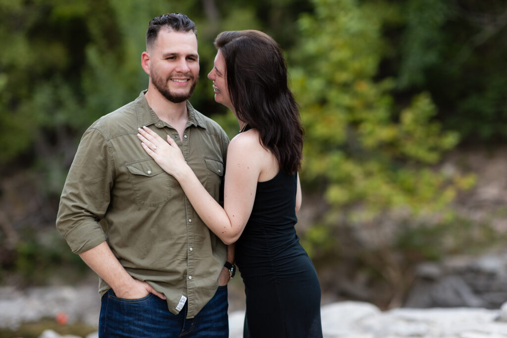 Engaged couple laughing together during engagement session at a park in Richardson TX