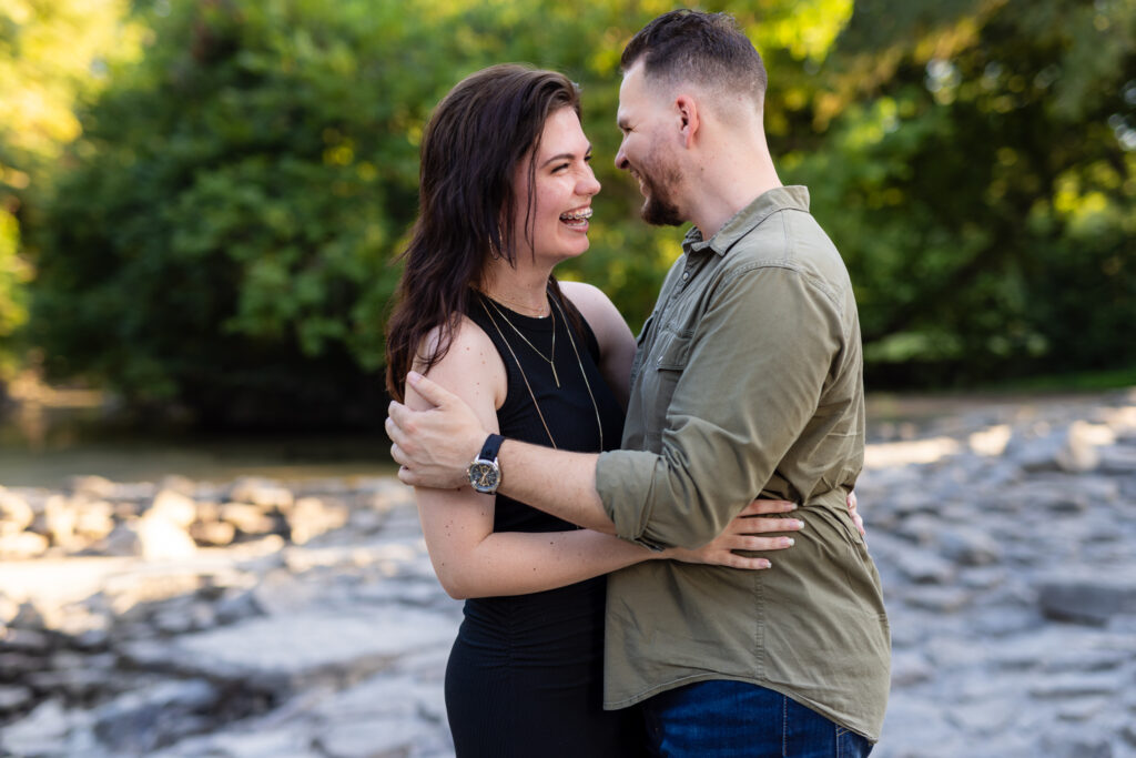 Engaged couple laughing while hugging during romantic engagement session at Richardson Park in TX