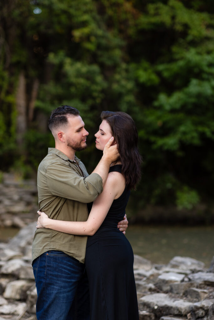 Engaged couple hugging intimately surrounded by lush greenery during Richardson Park engagement session in Texas