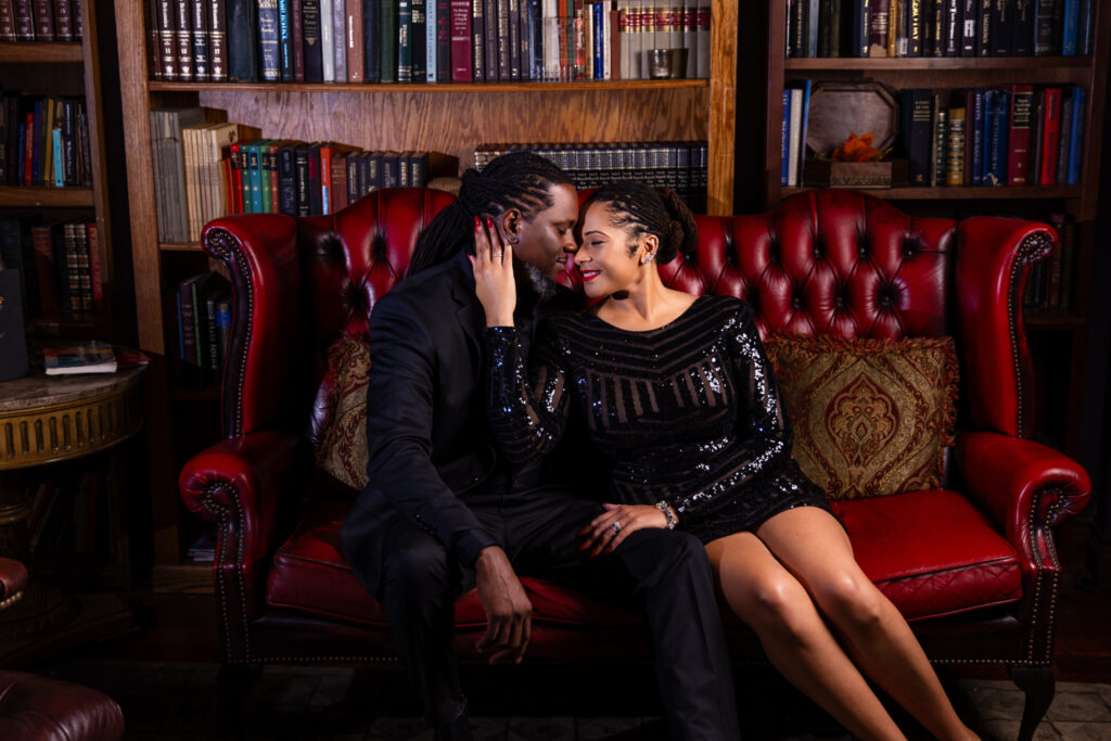 Woman sitting close to man foreheads together on red couch in vintage speakeasy in downtown Fort Worth