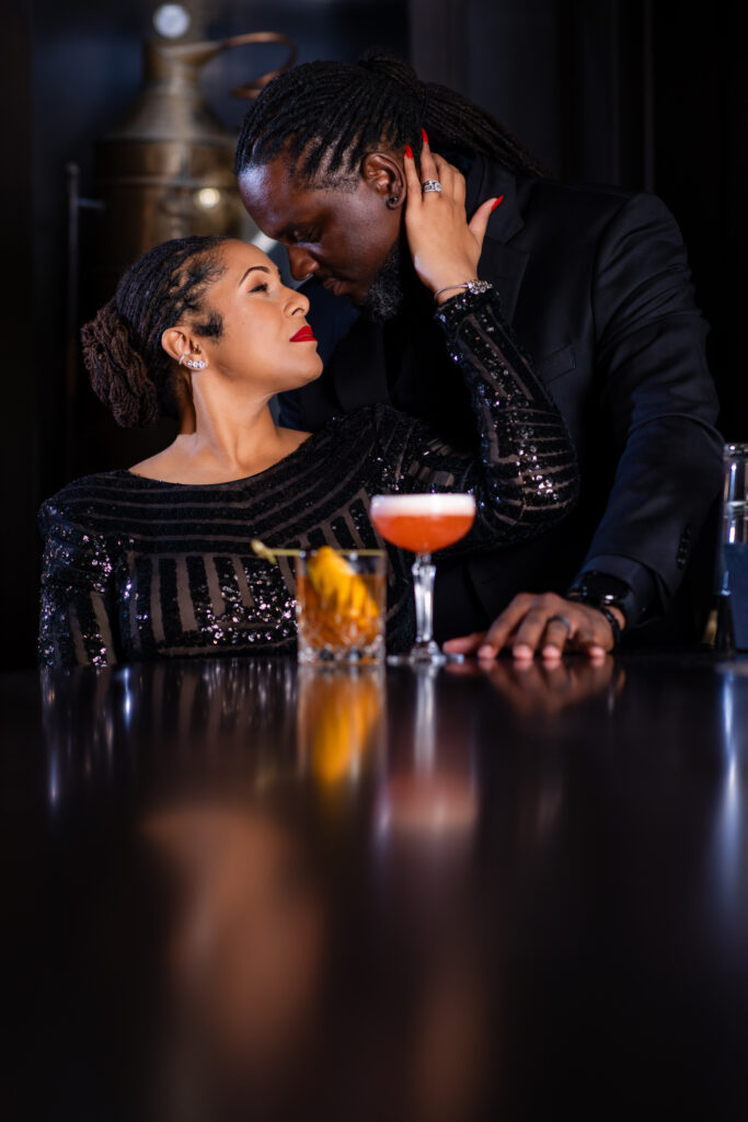 Woman looking up into man's eyes intimately during anniversary session at a bar