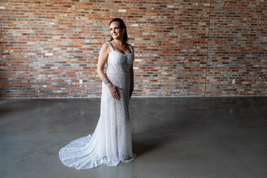 bride standing in front of brick wall in a Galia Lahav Oriana sparkling a-line wedding dress with a sweetheart neckline at Prosper Wine House