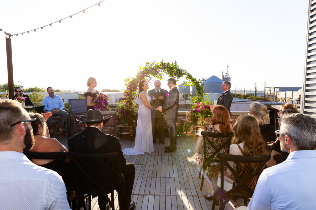 bridge and groom holding hands during rooftop ceremony at Prosper Wine House