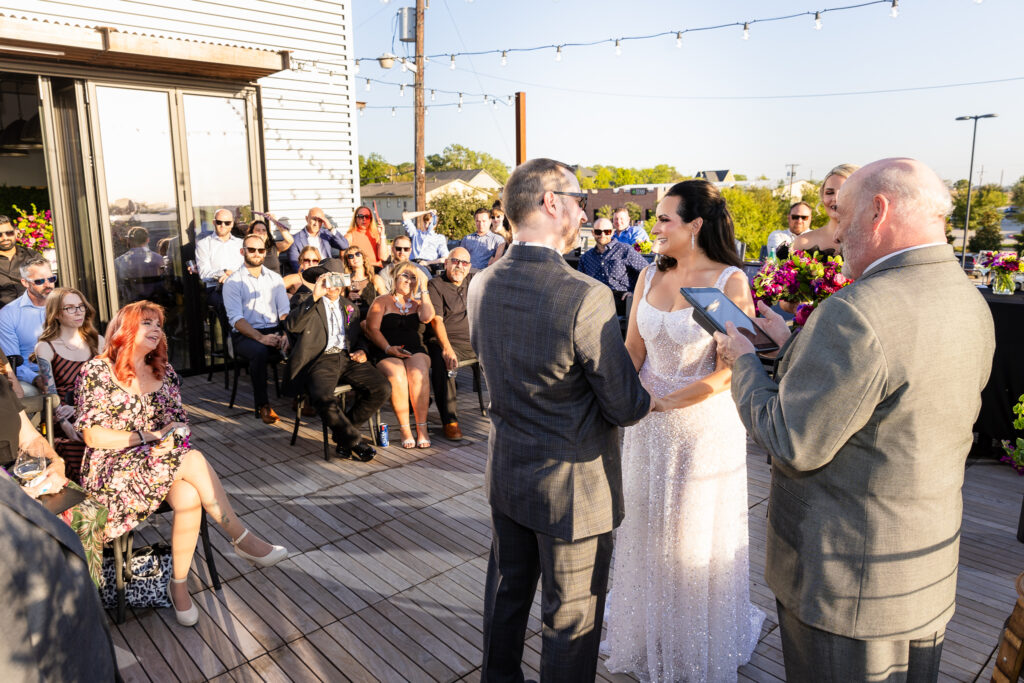 bridge and groom looking to guests during rooftop ceremony at Prosper Wine House