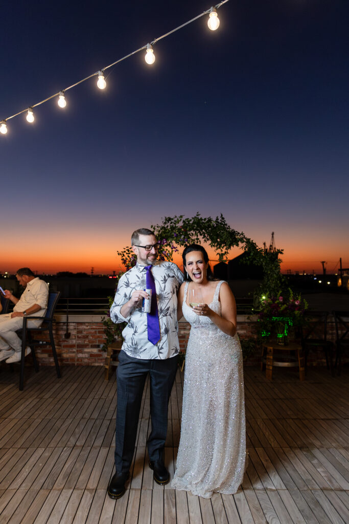 bride in a Galia Lahav Oriana sparkling a-line wedding dress laughing with groom on rooftop at Prosper Wine House at sunset in Prosper