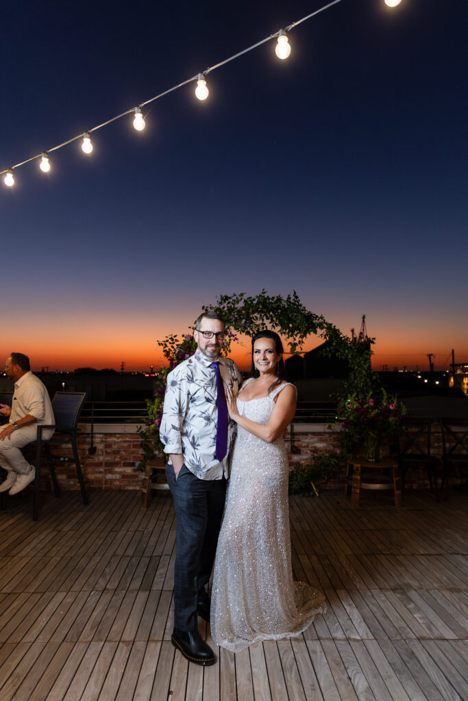 bride in a Galia Lahav Oriana sparkling a-line wedding dress smiling with groom on rooftop at Prosper Wine House at sunset in Prosper TX