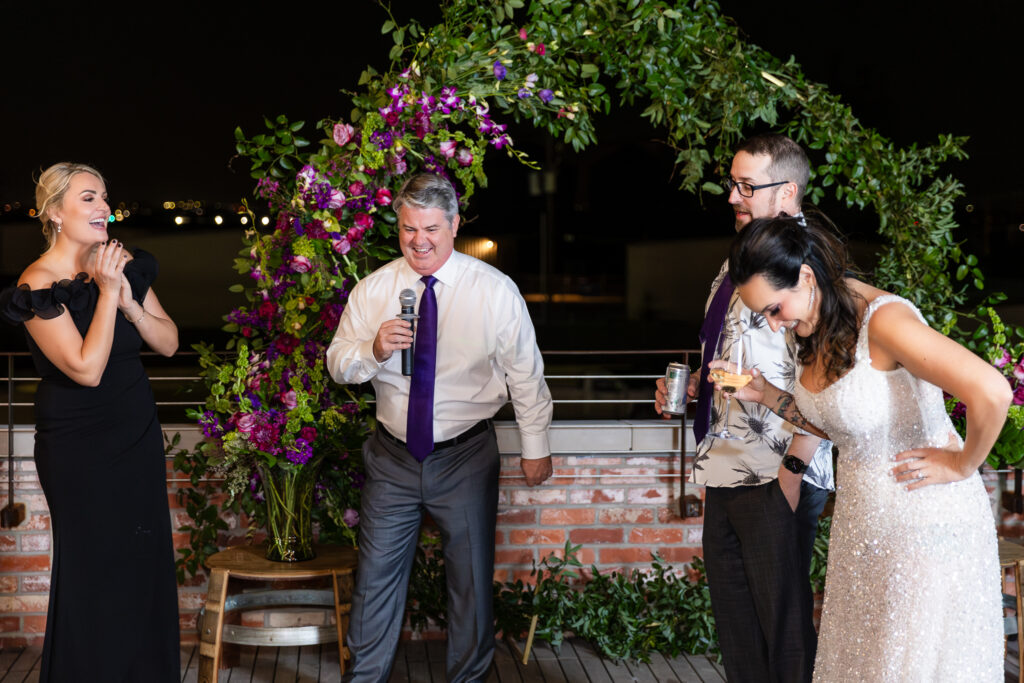 best man giving speech during wedding reception on rooftop of Prosper Wine House