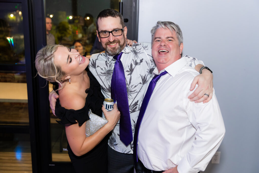 groom smiling with friends on dance floor during wedding reception