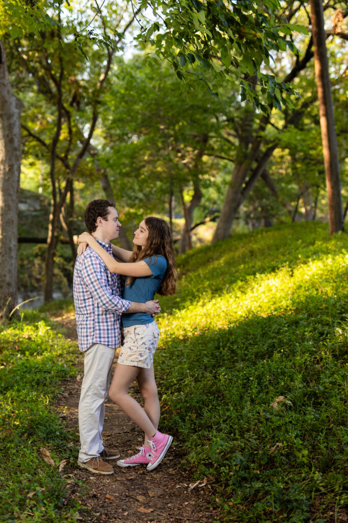 engaged couple standing chest to chest looking at each other in the woods at Prather Park in Dallas