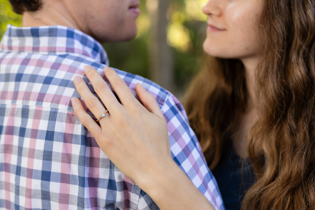 close up of engagement ring during engagement session in park