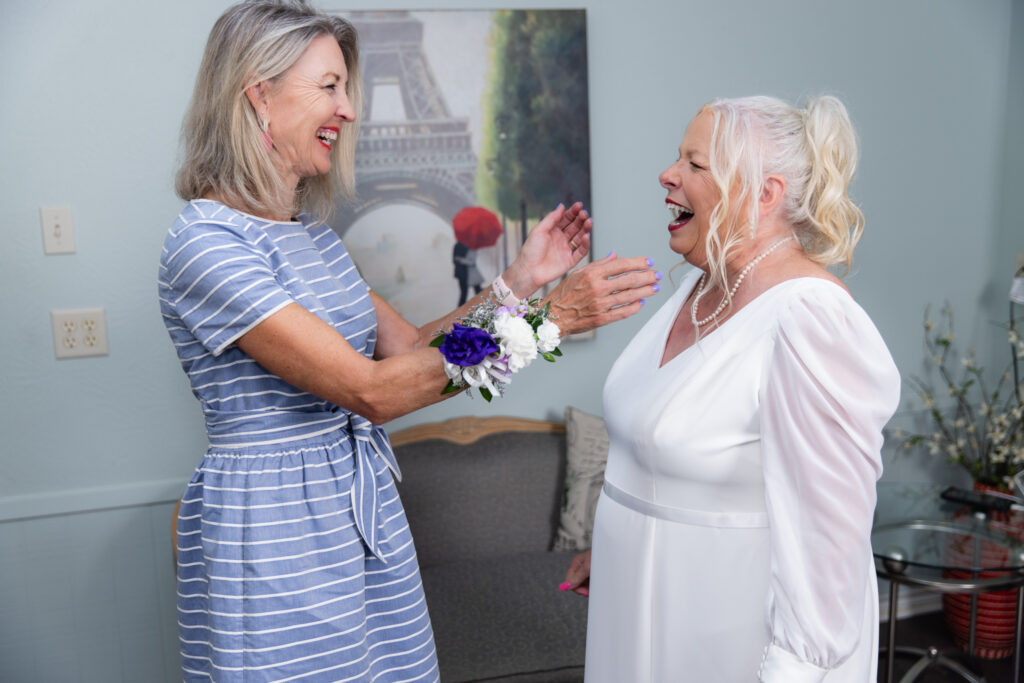 bride and friend laughing in The Abbey's bridal suite