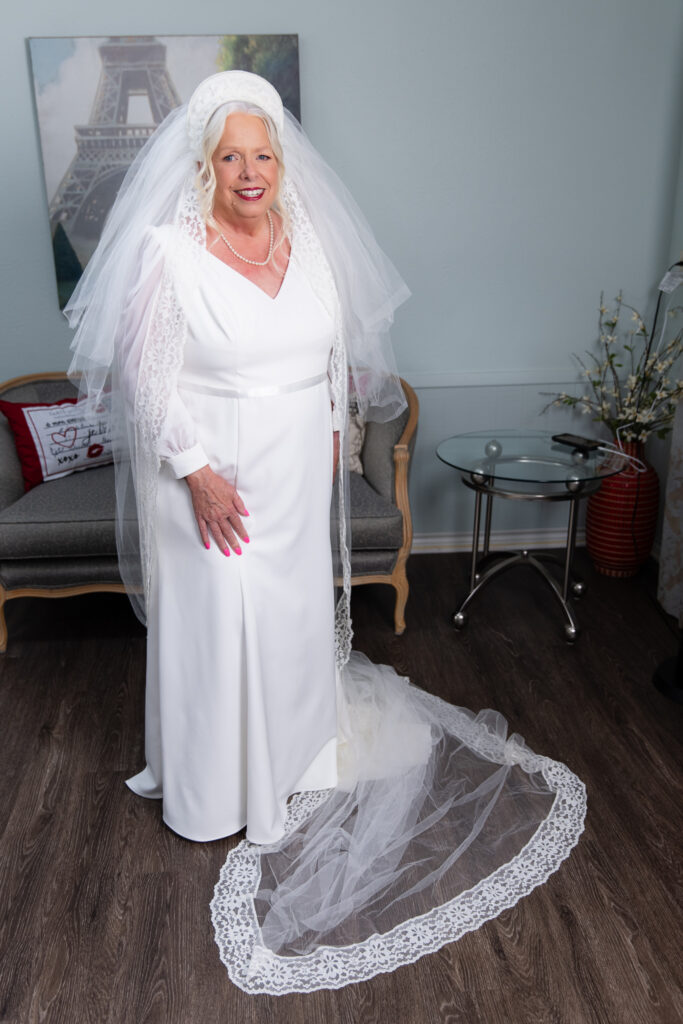 Bride wearing white gown and custom handmade veil and headpiece she handmade in 1974