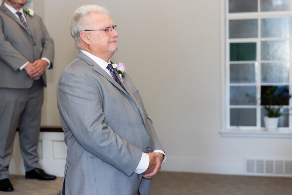 groom getting emotional standing at the end of the altar in the chapel at The Abbey wedding venue