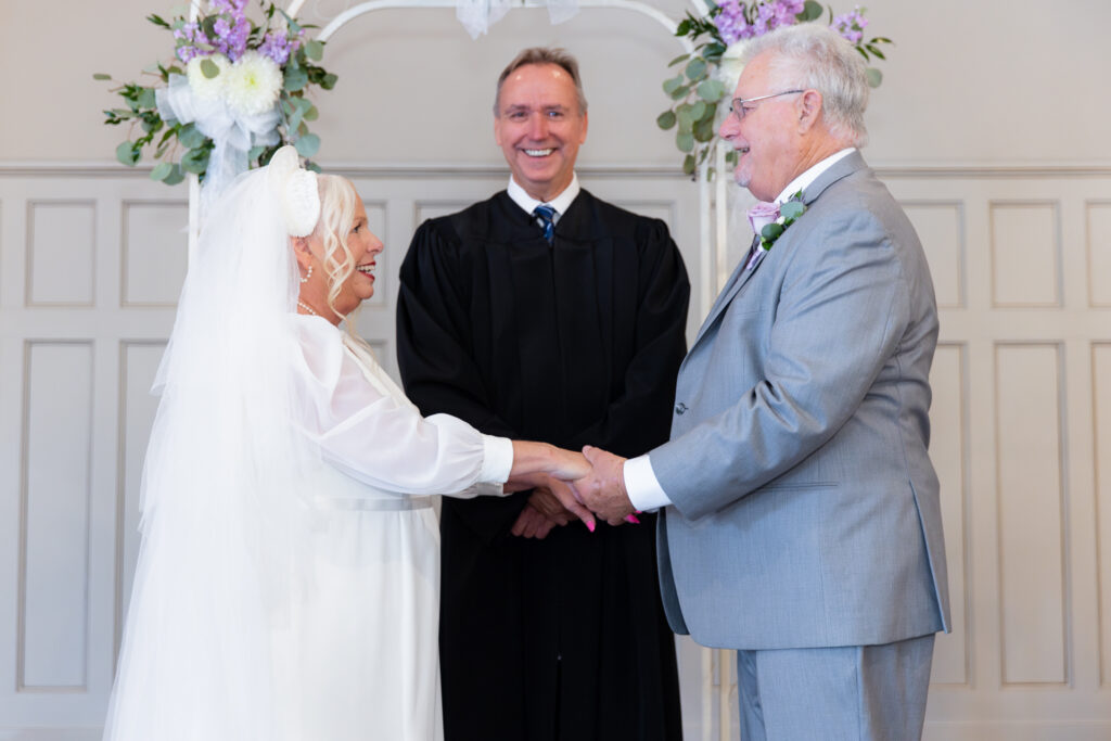 elderly bride and groom holding hands during 50th vow renewal