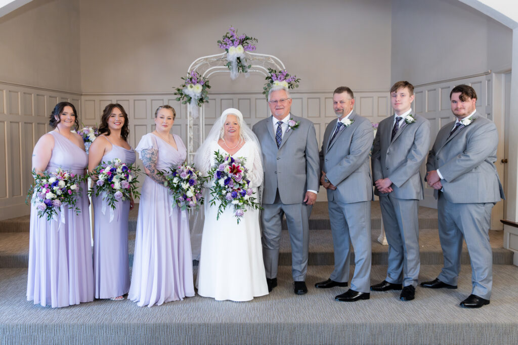 bride and groom standing at the altar with family during vow renewal at The Abbey wedding venue in Justin Texas