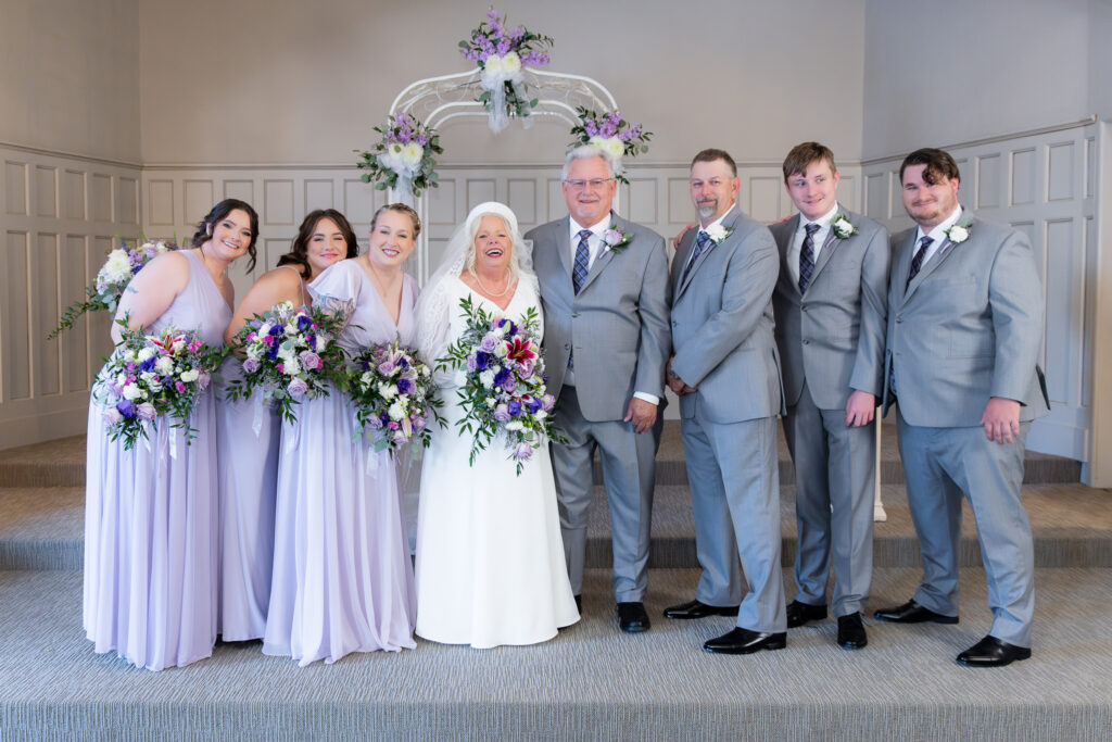 bride and groom standing at the altar with family during vow renewal at The Abbey wedding venue