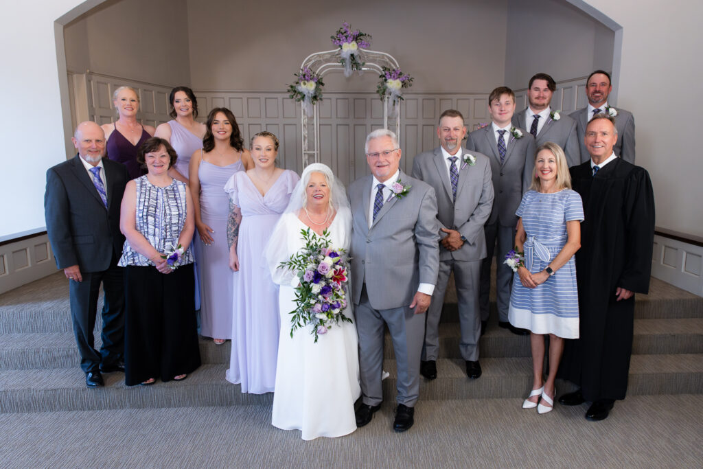 bride and groom standing at the altar with friends and family during vow renewal at The Abbey wedding venue