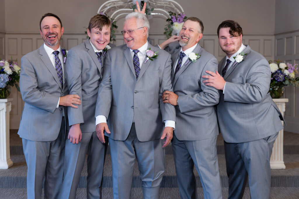 groom standing at the altar with family during vow renewal at The Abbey wedding venue in Justin TX