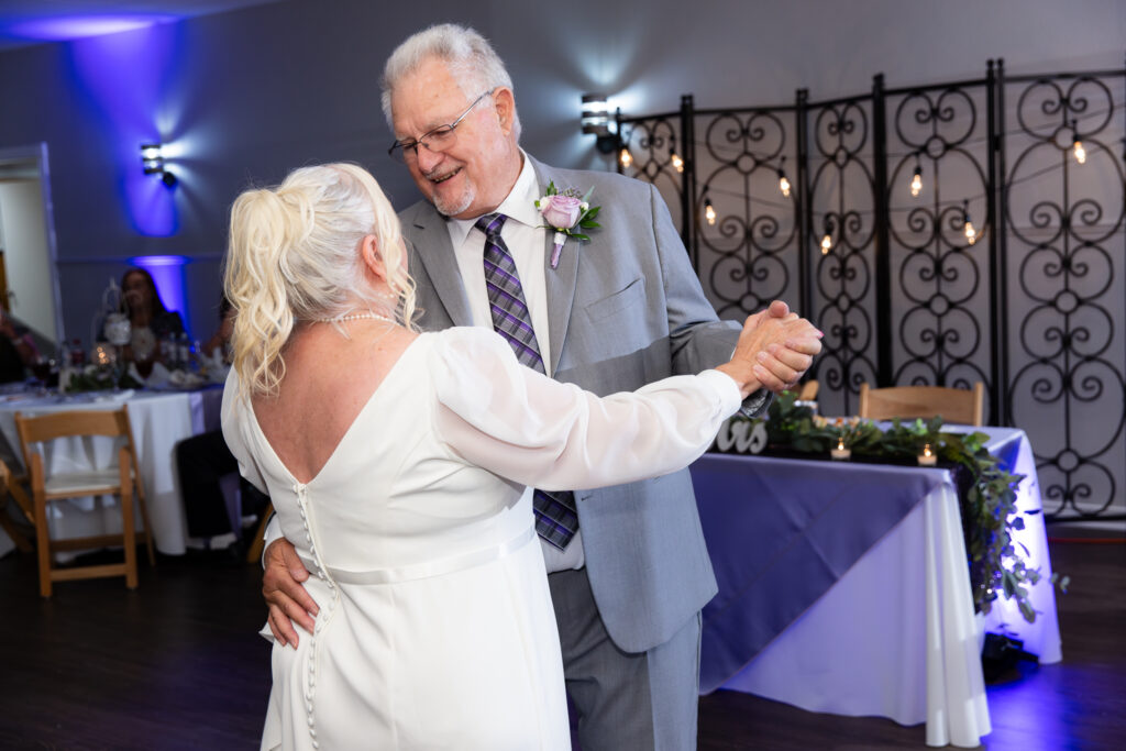 elderly bride and groom dancing during reception for 50th vow renewal at The Abbey wedding venue in Justin