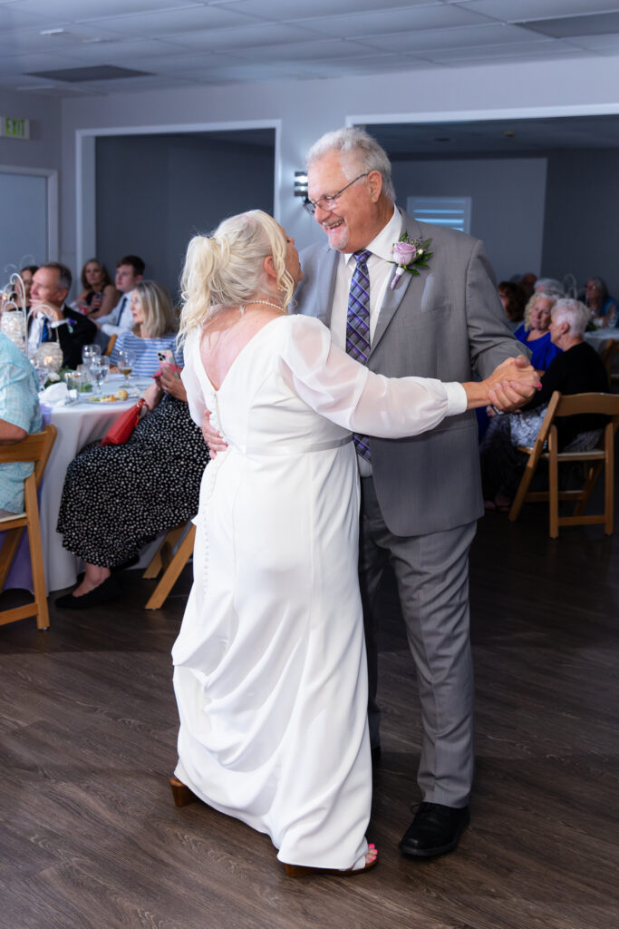 elderly bride and groom singing and dancing during reception for 50th vow renewal at The Abbey wedding venue