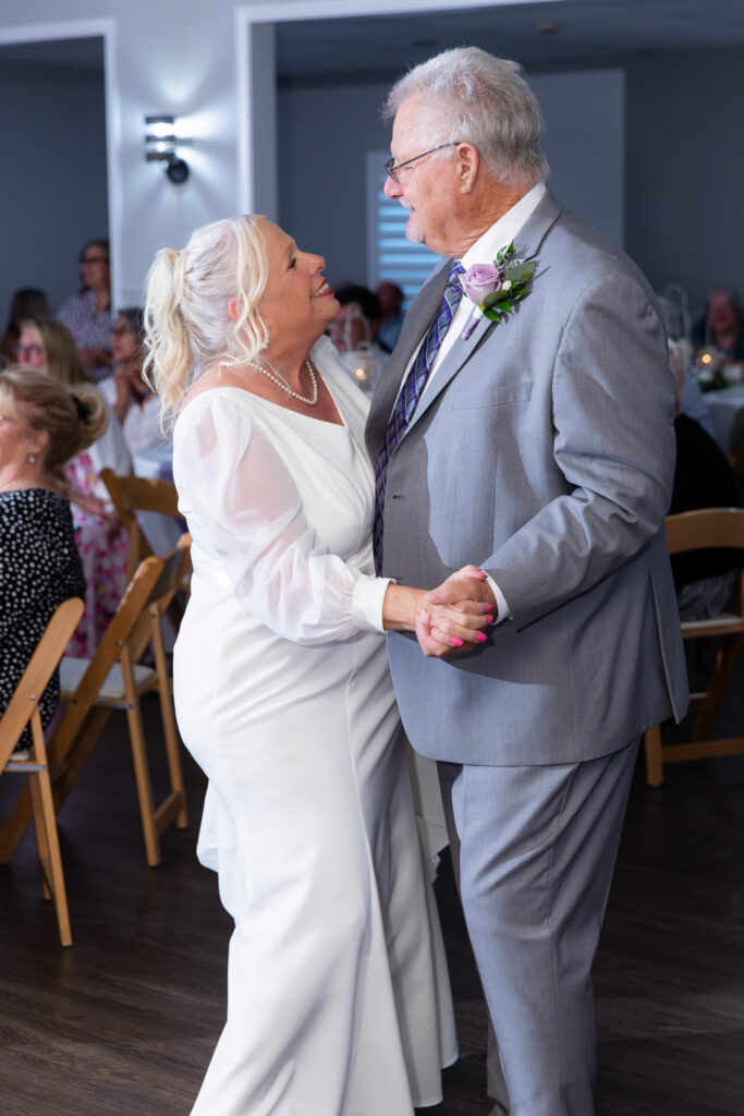 elderly bride and groom smiling and dancing during reception for 50th vow renewal at The Abbey