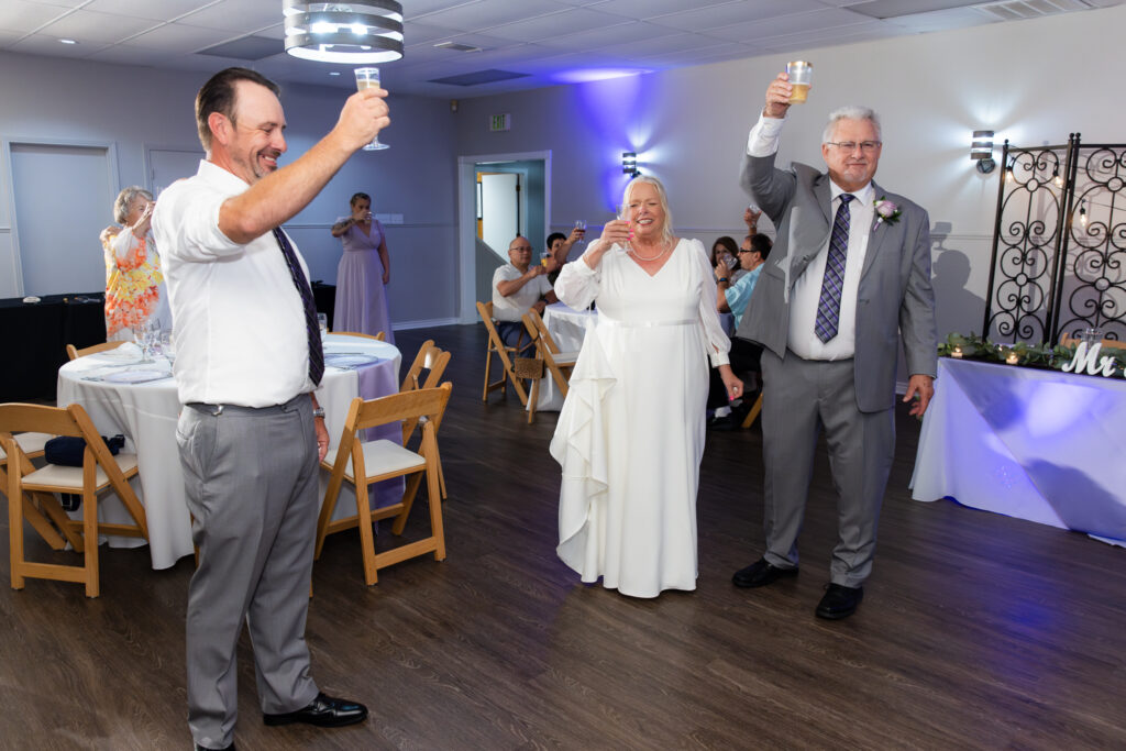 son giving a toast to elderly bride and groom in the reception hall at The Abbey wedding venue