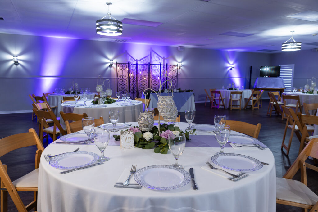 decorated reception hall at The Abbey wedding venue in Justin TX with blue uplights