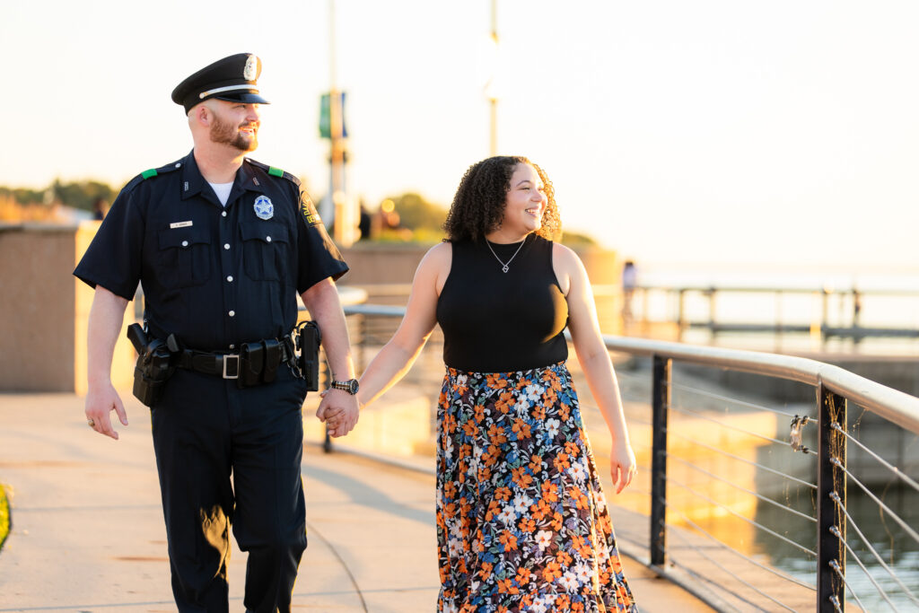 engaged couple holding hands smiling out towards Rockwall lake