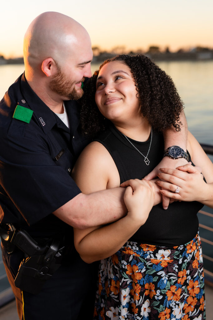 man hugging woman from behind smiling at each other during Rockwall engagement session