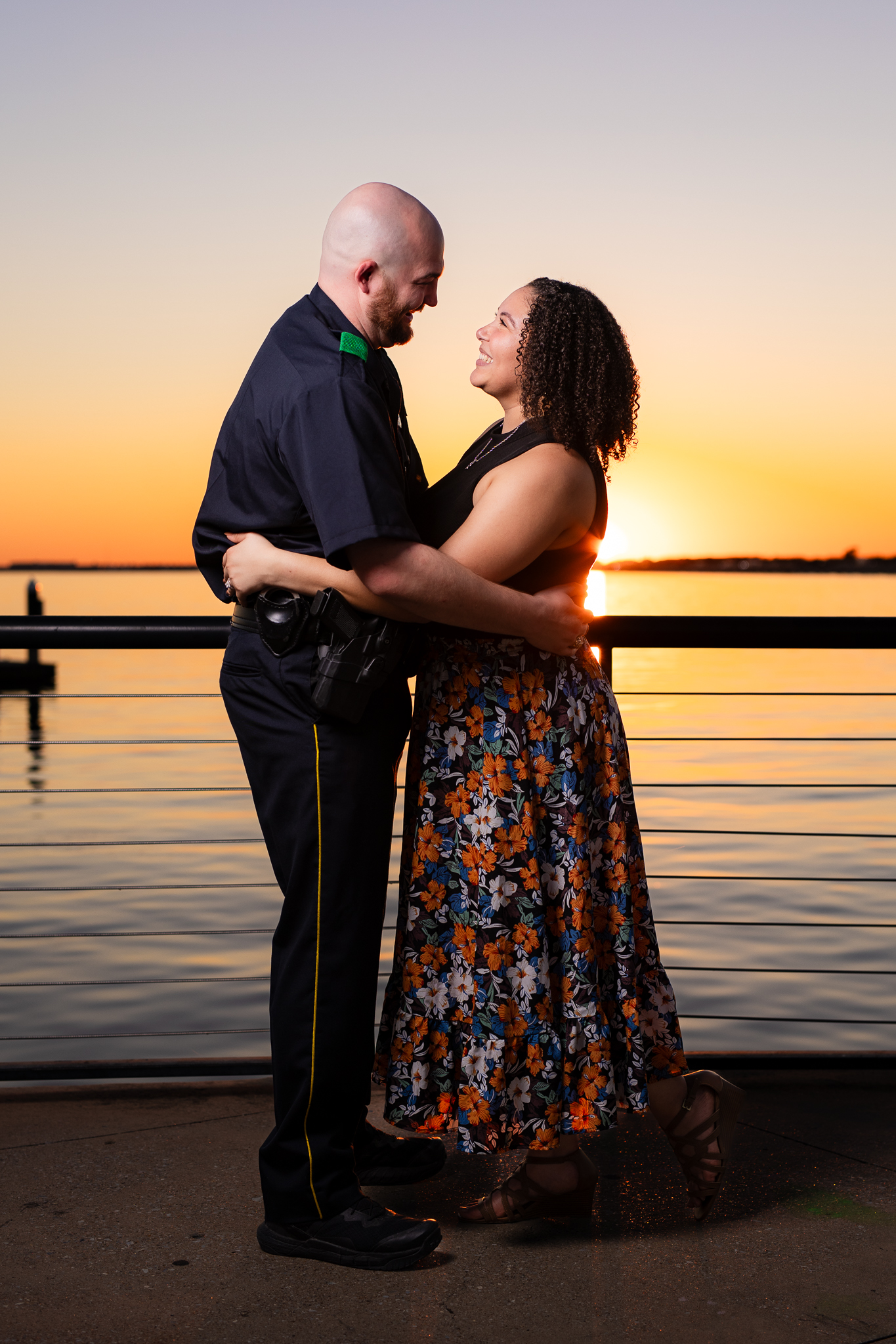 engaged couple hugging at sunset by lake in Rockwall