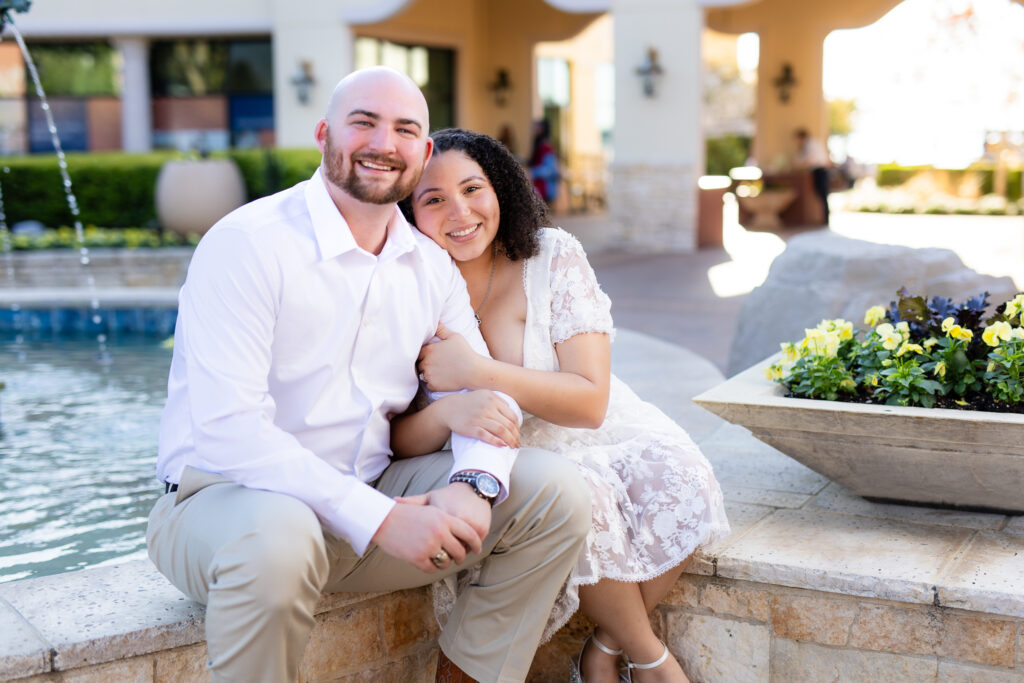 engaged couple sitting and cuddling together during engagement session