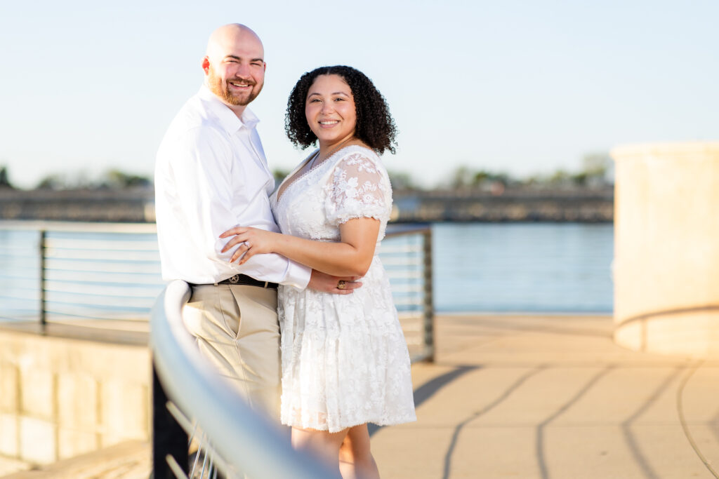 man and woman wearing all white smiling at camera by lake in Rockwall TX